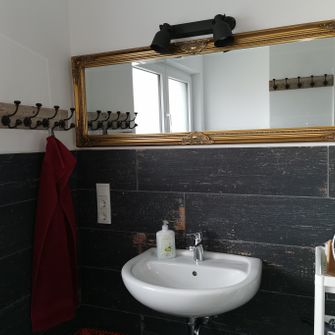 Badezimmer mit goldenem Barockspiegel.